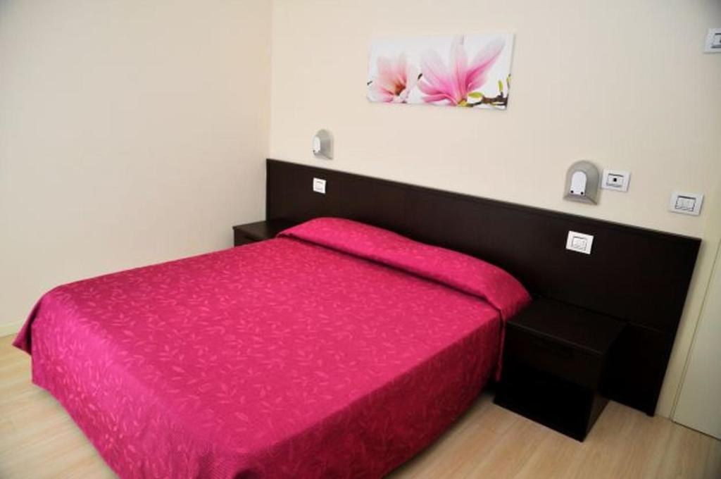 A bed or beds in a room at Hotel Lugano