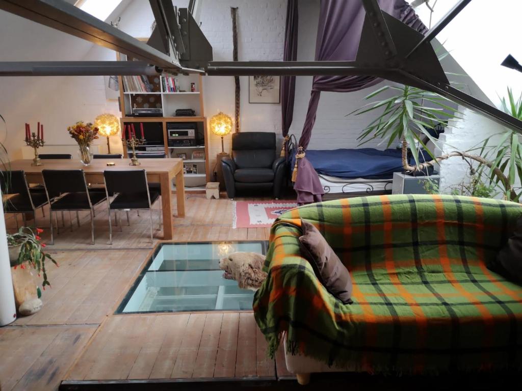 een woonkamer met een bank en een glazen vloer bij Artistic loft apartment with big sun terrace in Gent