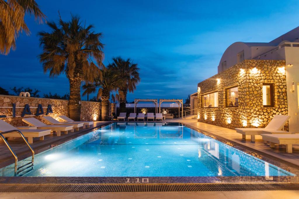 a swimming pool with lounge chairs next to a building at ILIADA-ODYSSEAS RESORT in Perivolos