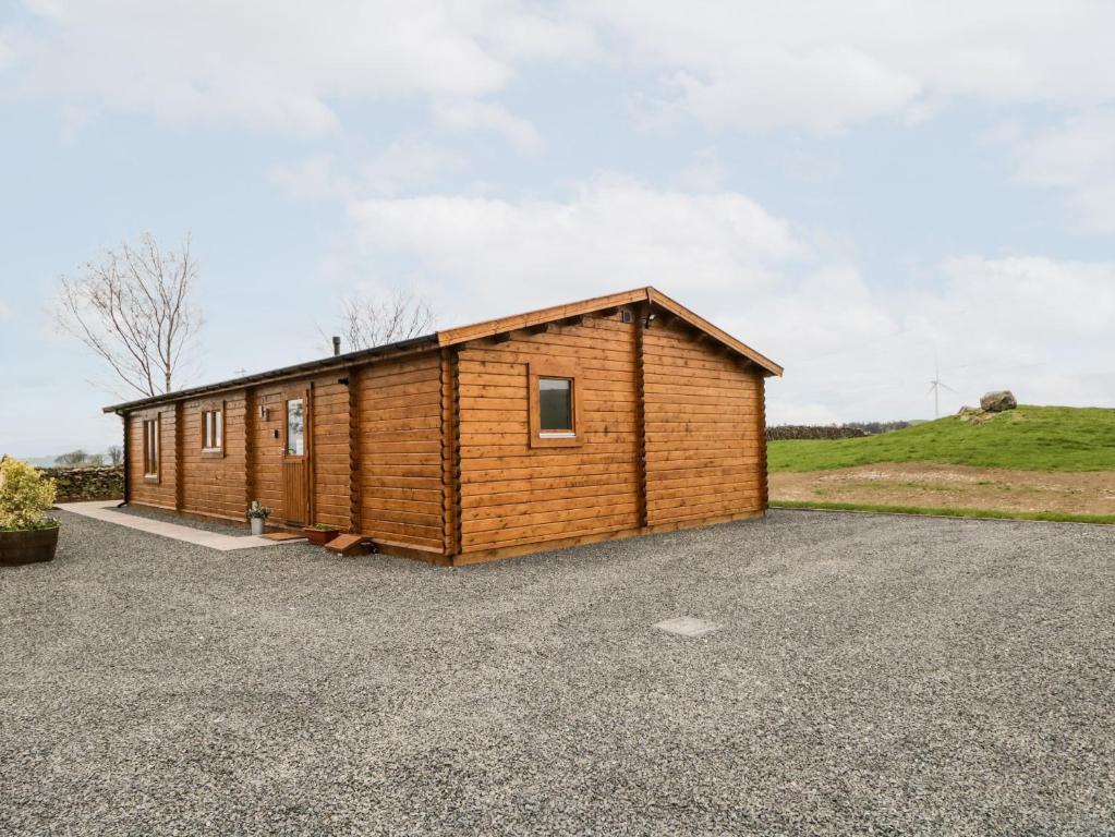 eine kleine Holzhütte auf einem Schotterparkplatz in der Unterkunft Howgills Retreat in Kendal