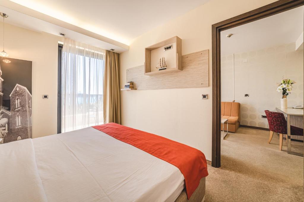 a hotel room with a bed and a table at Hotel & Apartments HEC Residence in Sveti Stefan
