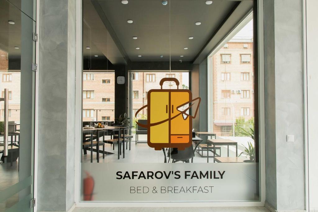 ein Schild in einem Fenster mit einem gelben Koffer in der Unterkunft Safarov's Family Hostel in Taschkent
