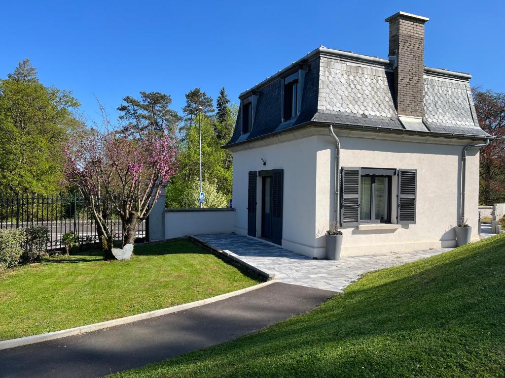 una pequeña casa blanca con un patio de césped en La Petite Maison 1933, en Vesoul