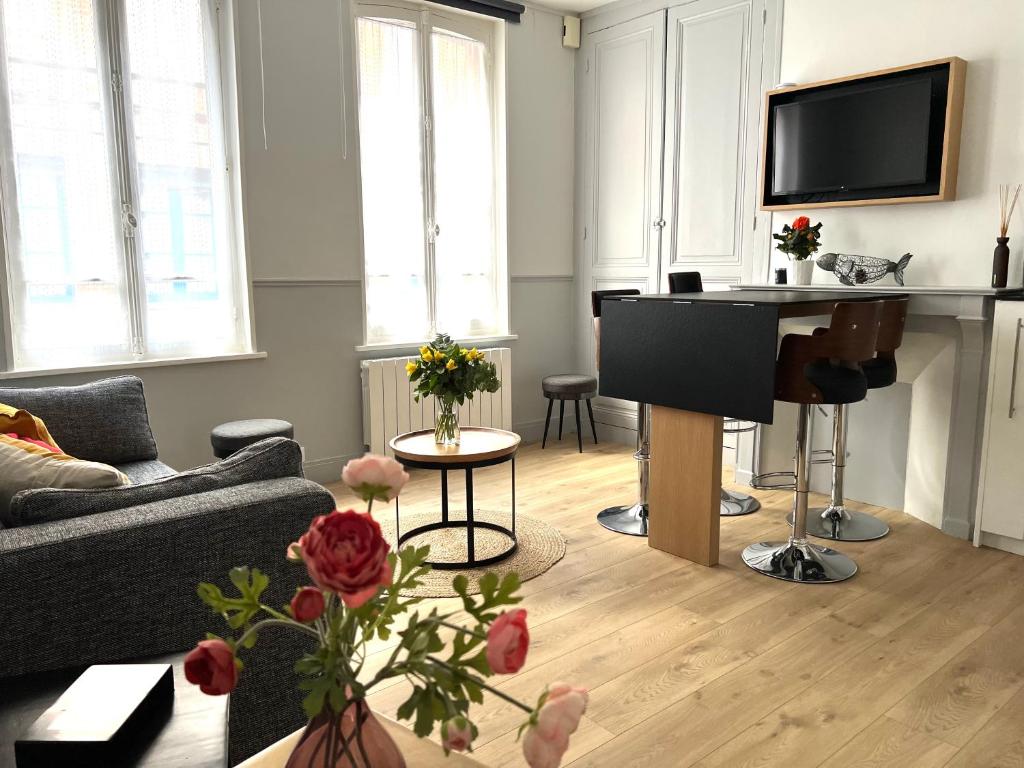 een woonkamer met een bank en een piano bij L'évasion in Honfleur