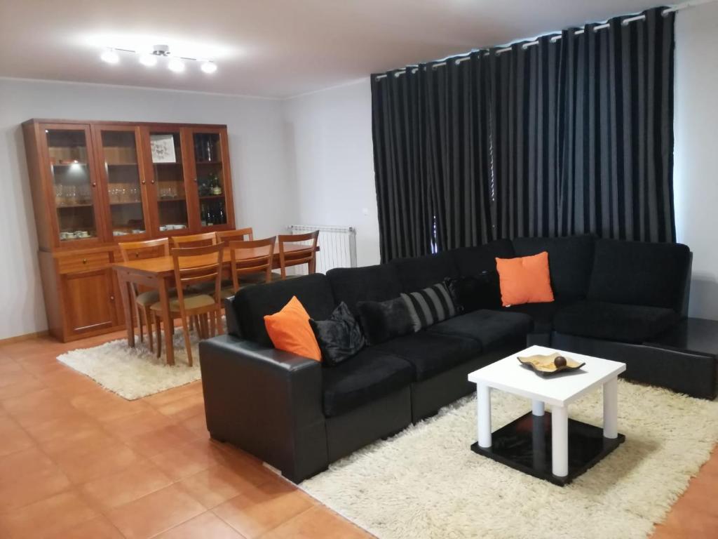 a living room with a black couch and a table at CASA VISTA RIO ESPOSENDE in Esposende