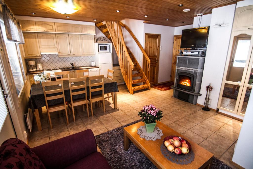 een woonkamer en een keuken met een tafel en een open haard bij Vuokatti Apartments in Vuokatti