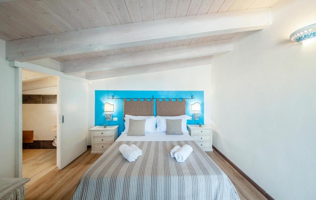 um quarto com uma cama grande e paredes azuis em Rocca Doria em Castelsardo