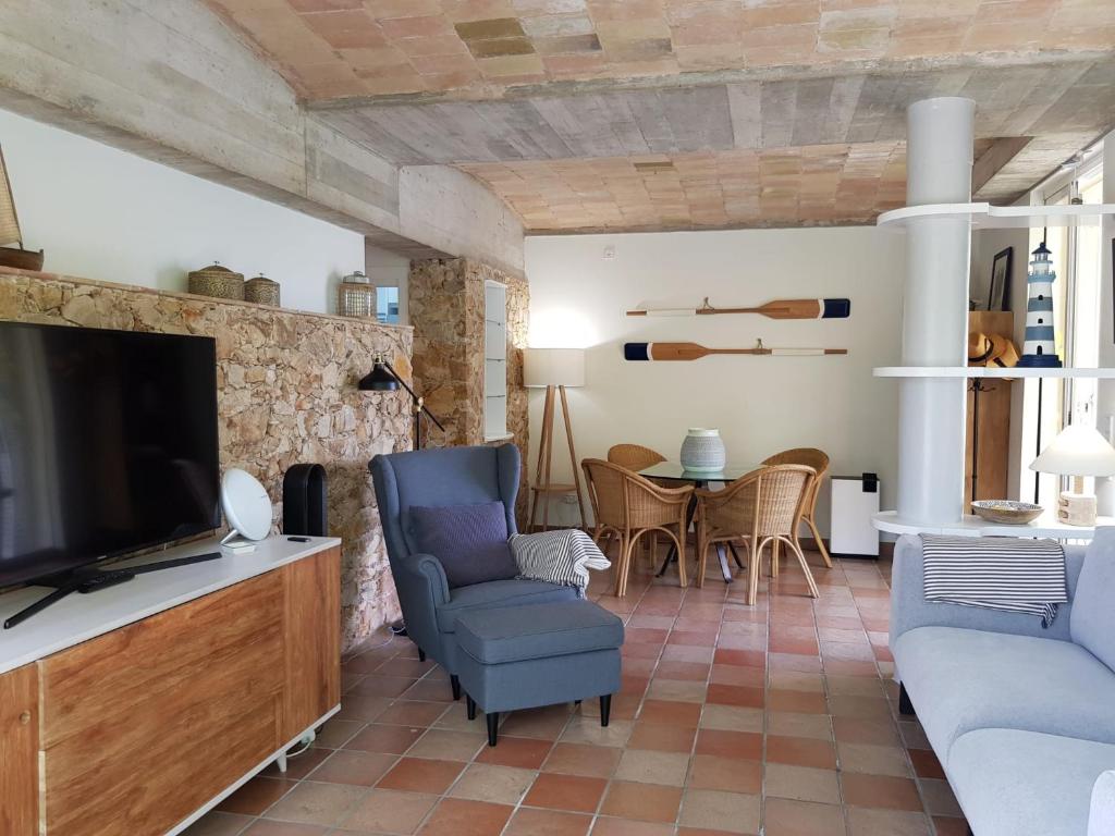 een woonkamer met een tv en stoelen en een tafel bij MACH HOUSE you will like it ! in Tamariu