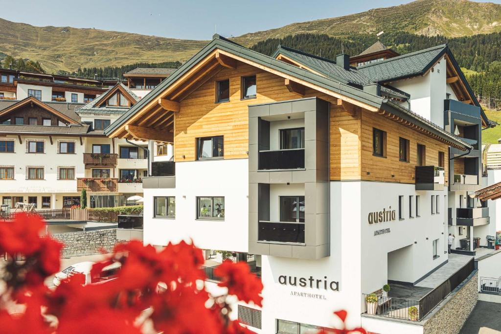 a building with a wooden roof on top of it at Austria Aparthotel in Fiss