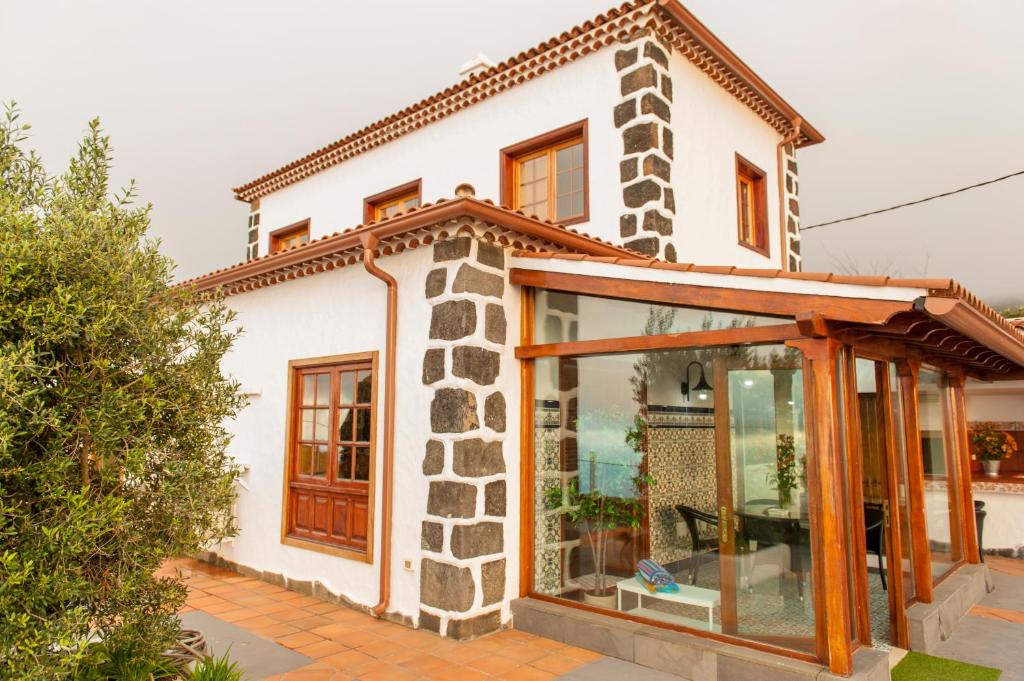 una pequeña casa blanca con una extensión de cristal en Villa Finca Los Castanos - Panoramic View, en Santa Cruz de Tenerife