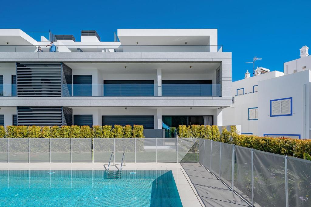 - un grand bâtiment blanc avec une piscine en face dans l'établissement Cabanas Seaside, à Tavira