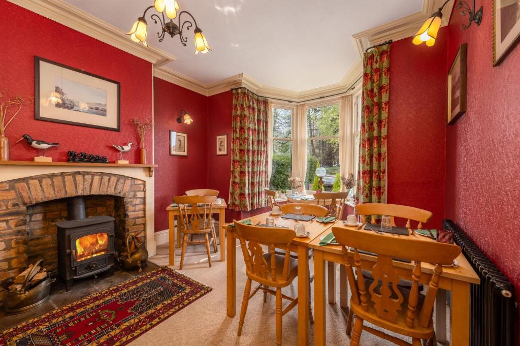 a dining room with a fireplace and a table and chairs at Burnside B&B in Keswick