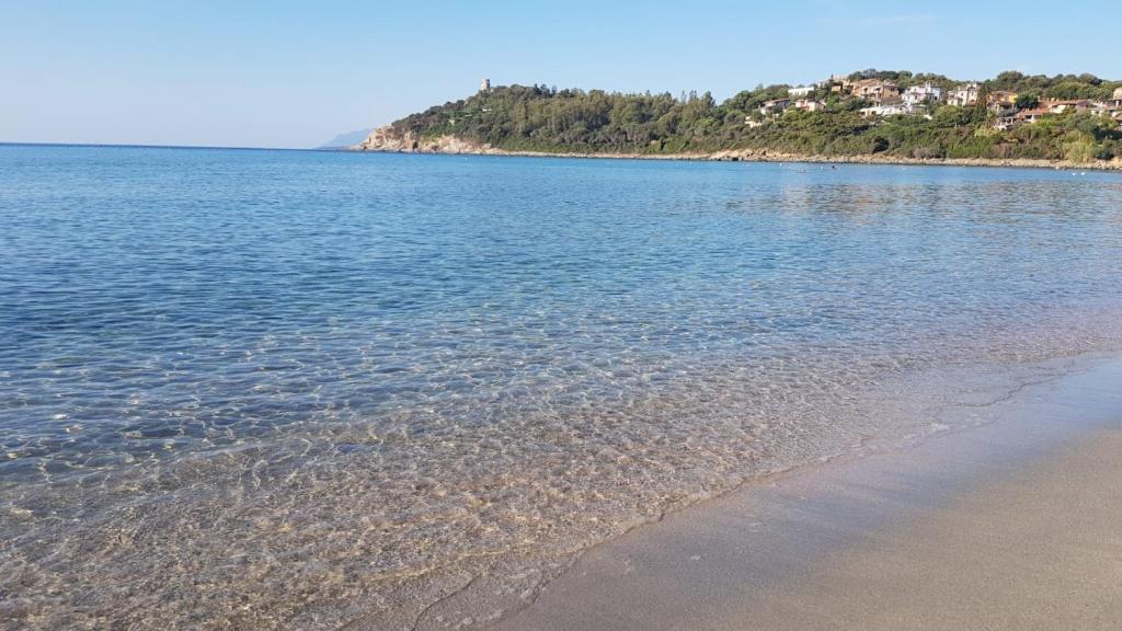 a body of water with a sandy beach and houses at La Gioia di Casa in Àrbatax