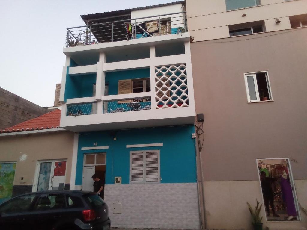 una casa azul y blanca con un coche aparcado delante en In The Heart Of Praia - Family B&B en Praia
