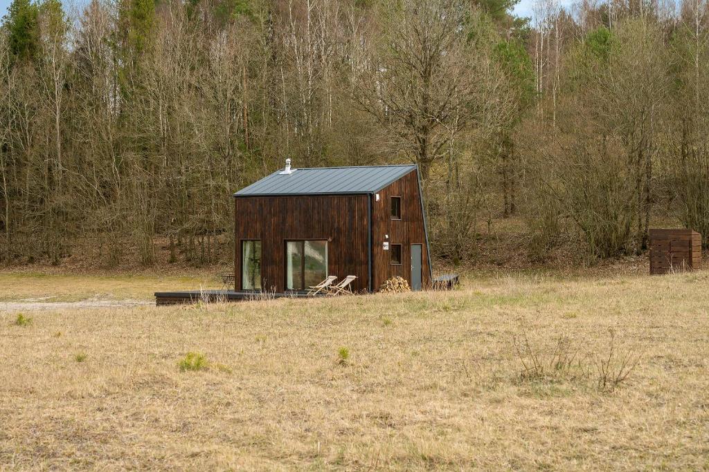 a wooden cabin in the middle of a field at Domek Trzy Rzeki in Załęże