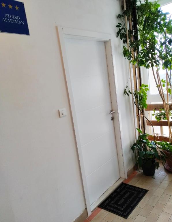 a white door in a room with plants at sky in Pula
