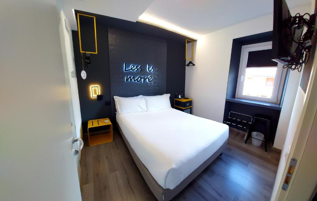 - une chambre avec un lit blanc et un mur noir dans l'établissement Hotel Aurora Duino, à Duino