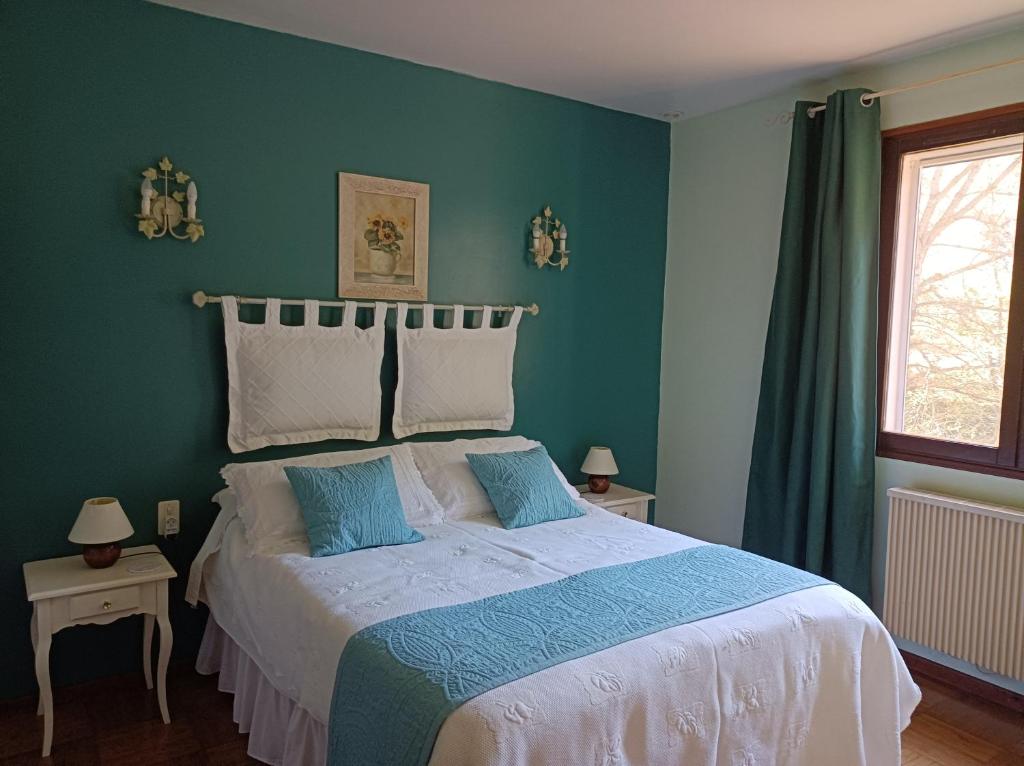 ein Schlafzimmer mit einem großen Bett mit grünen Wänden in der Unterkunft Les Eaux Tranquilles in Belvianes-et-Cavirac