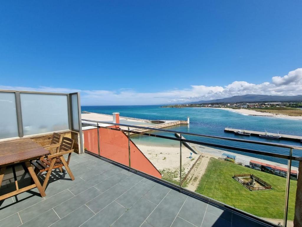 balcón con mesa y vistas al océano en Mirador al Cantabrico, en Foz