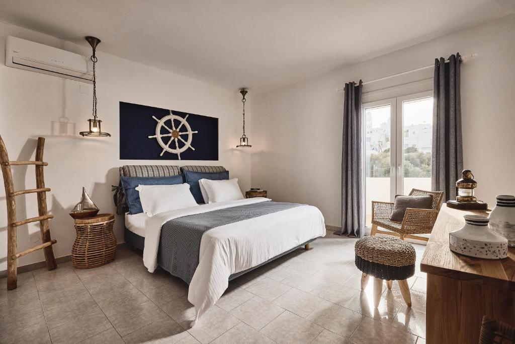 a bedroom with a large bed and a large window at Capetan Giorgantas in Adamas
