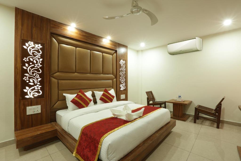 a bedroom with a large bed and a table and chairs at Hotel Katra Grand A Unit of Mal Mai Group in Katra