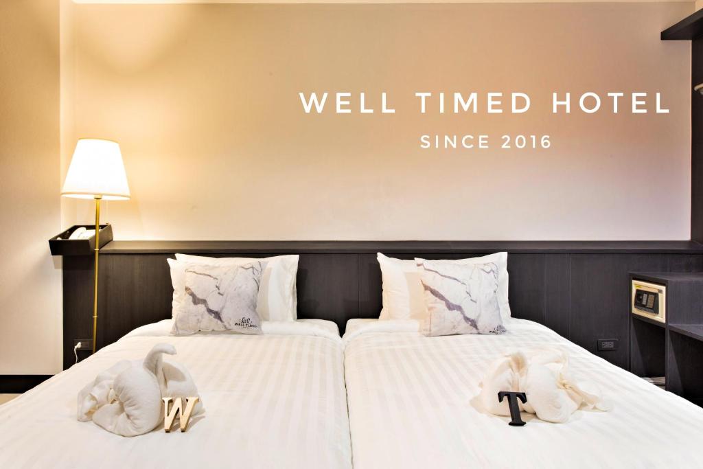 een hotelkamer met 2 bedden en handdoeken erop bij Well Timed Hotel in Krabi town