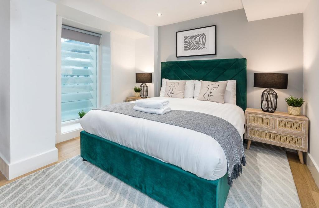 a bedroom with a large bed with a green headboard at Host & Stay - The Cavern Quarter Apartment in Liverpool