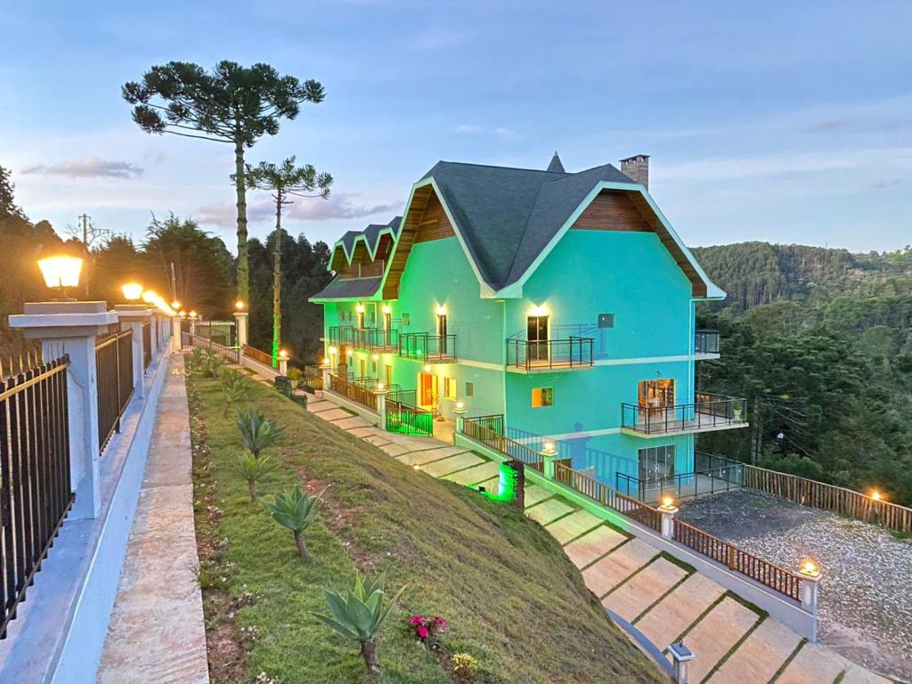 une maison au sommet d'une colline la nuit dans l'établissement Pousada Alpes Azul, à Campos do Jordão