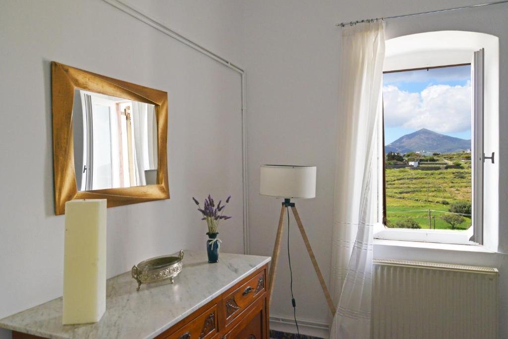 Cette chambre dispose d'une fenêtre et d'une table avec un miroir. dans l'établissement Diamanto's guest house, à Trypiti