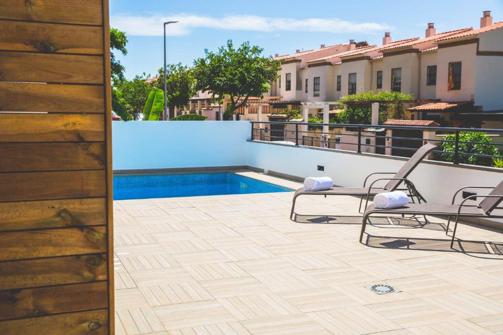 a patio with two chairs and a swimming pool at Apartamentos La Libertad 1 in Benalmádena