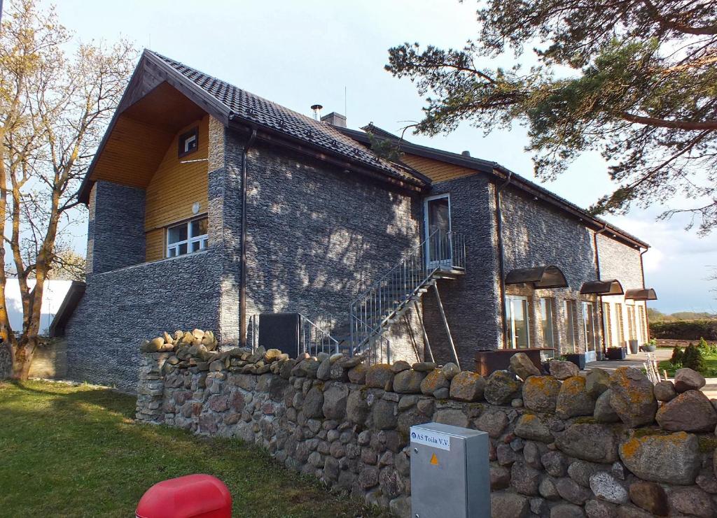 a brick house with a stone wall in front of it at Toila Pikk Apartment in Toila