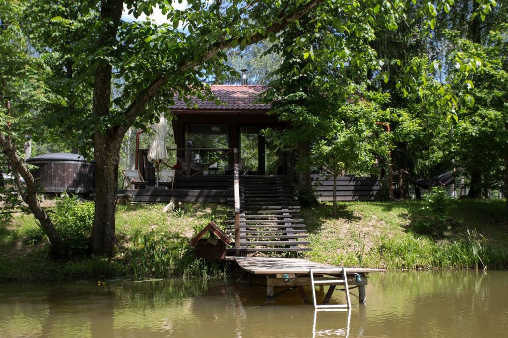 uma casa sentada ao lado de um rio em Annas Dzirnavas em Annas