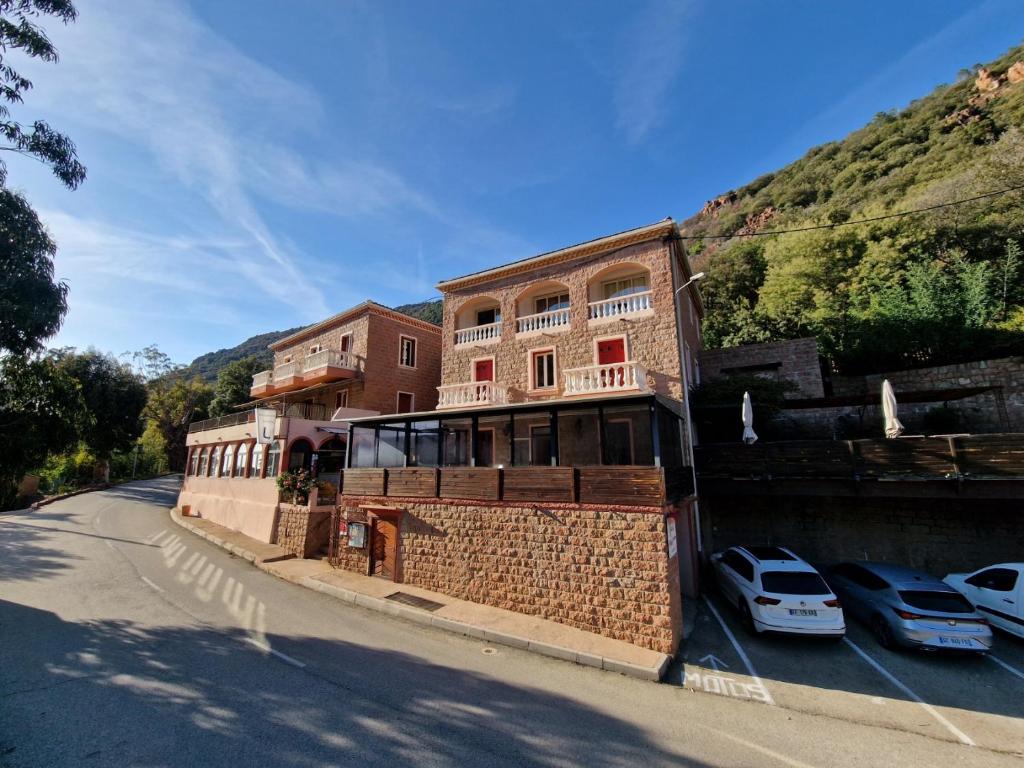 a building on the side of a road with parked cars at Hôtel Bella Vista in Porto Ota