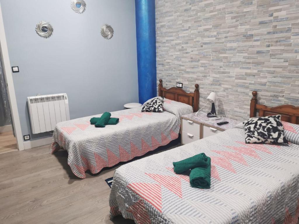a room with two beds and a brick wall at Centro de Baracaldo, parcela de garaje gratis in Barakaldo