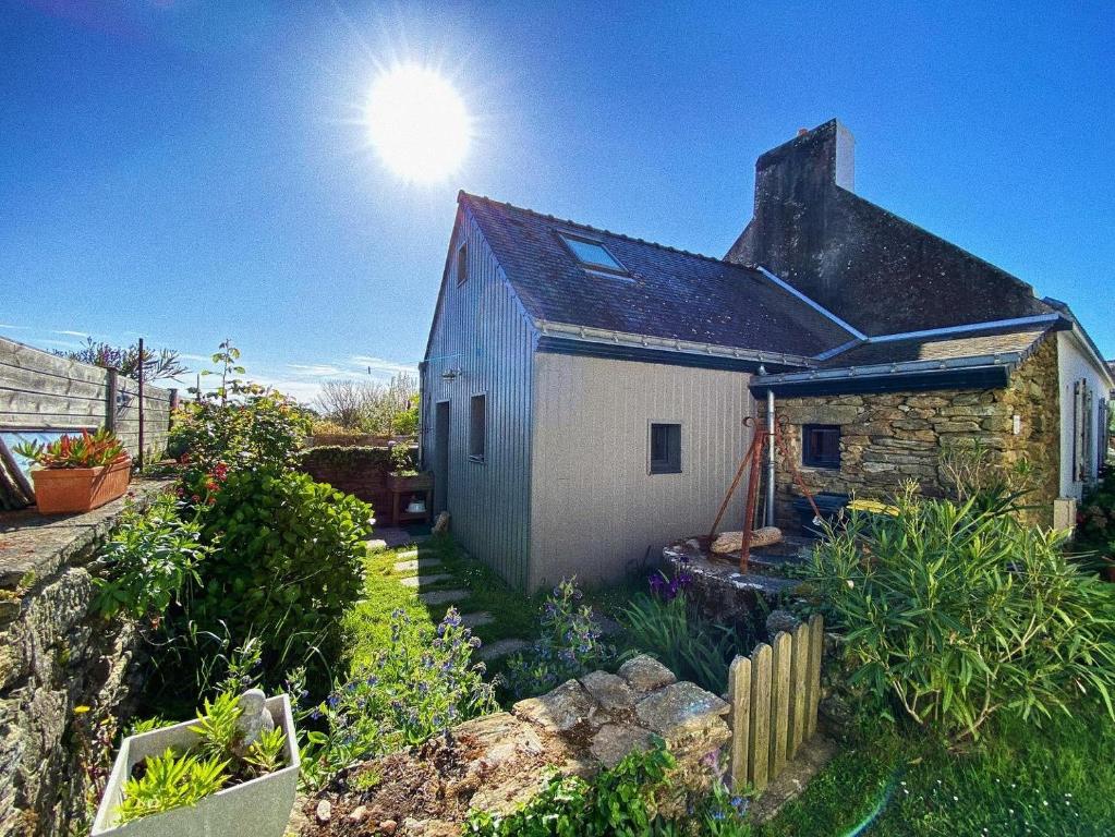 a small white house with the sun behind it at Chouk-Ezaï côte sauvage de l'île in Groix