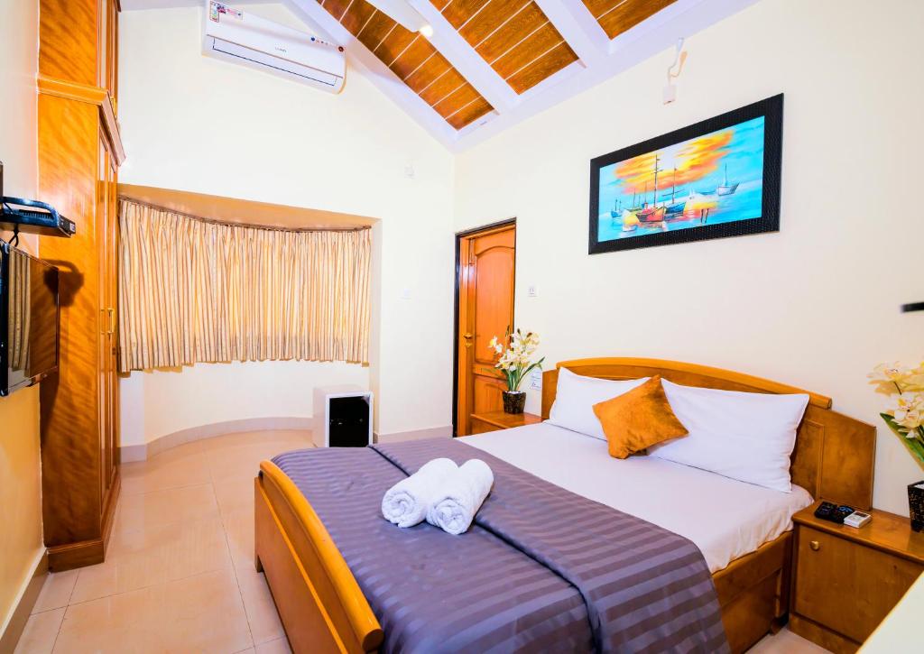 ein Schlafzimmer mit einem Bett mit zwei Handtüchern darauf in der Unterkunft 'Golden Oceans' 3 bhk beach view villa in Benaulim