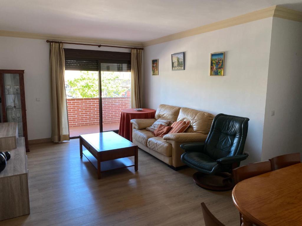 - un salon avec un canapé, une chaise et une table dans l'établissement Cala del Mar Apartment - La Cala de Mijas, à La Cala de Mijas