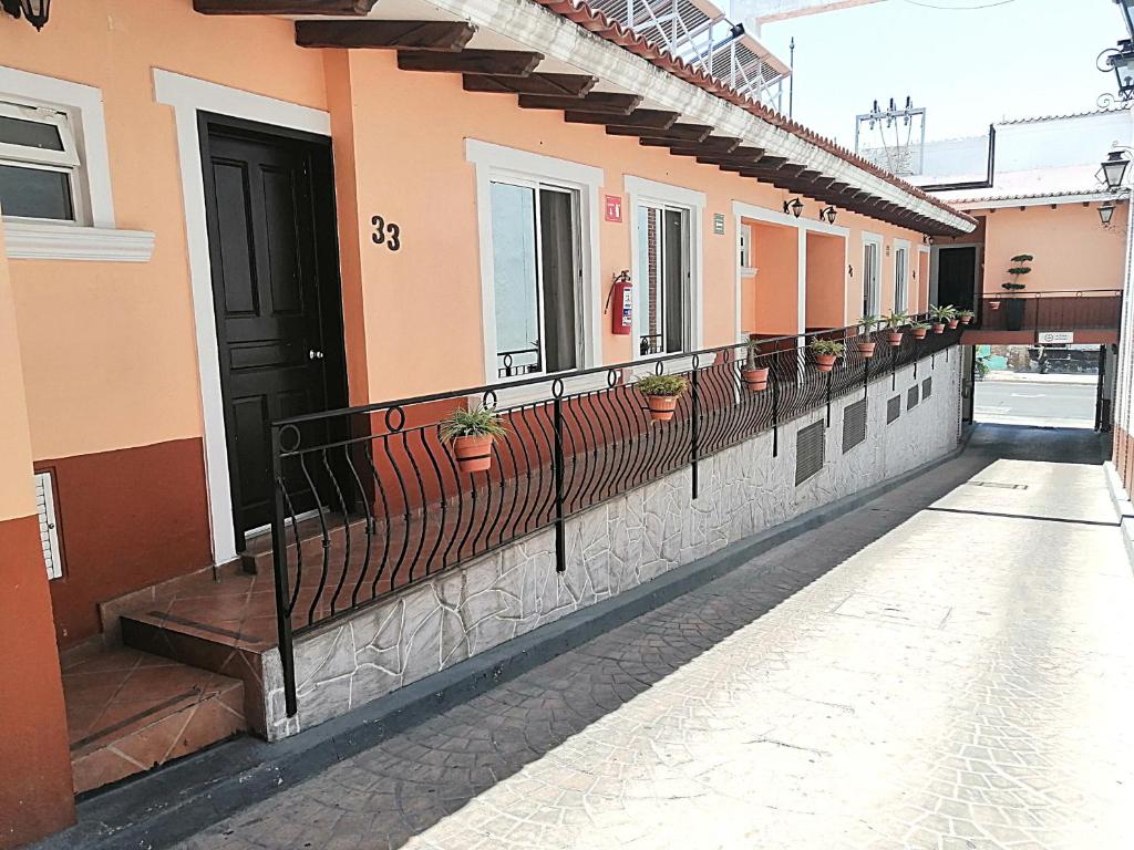 a building with potted plants on the side of it at Hotel Aquiles in Guadalajara