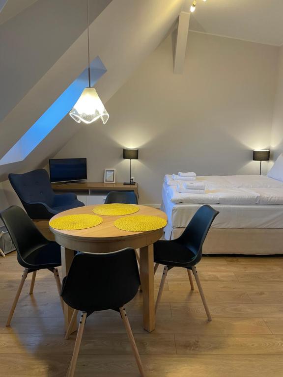 ソポトにあるPrzy Monciaku - Monte Cassino by OneApartmentsのテーブル、椅子、ベッドが備わる客室です。