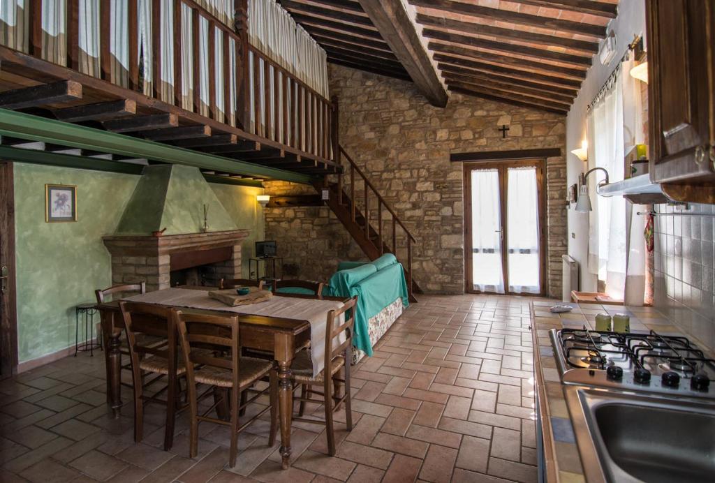 una cucina con tavolo, sedie e piano cottura di Bio Agriturismo Montemenardo Apartments a Todi