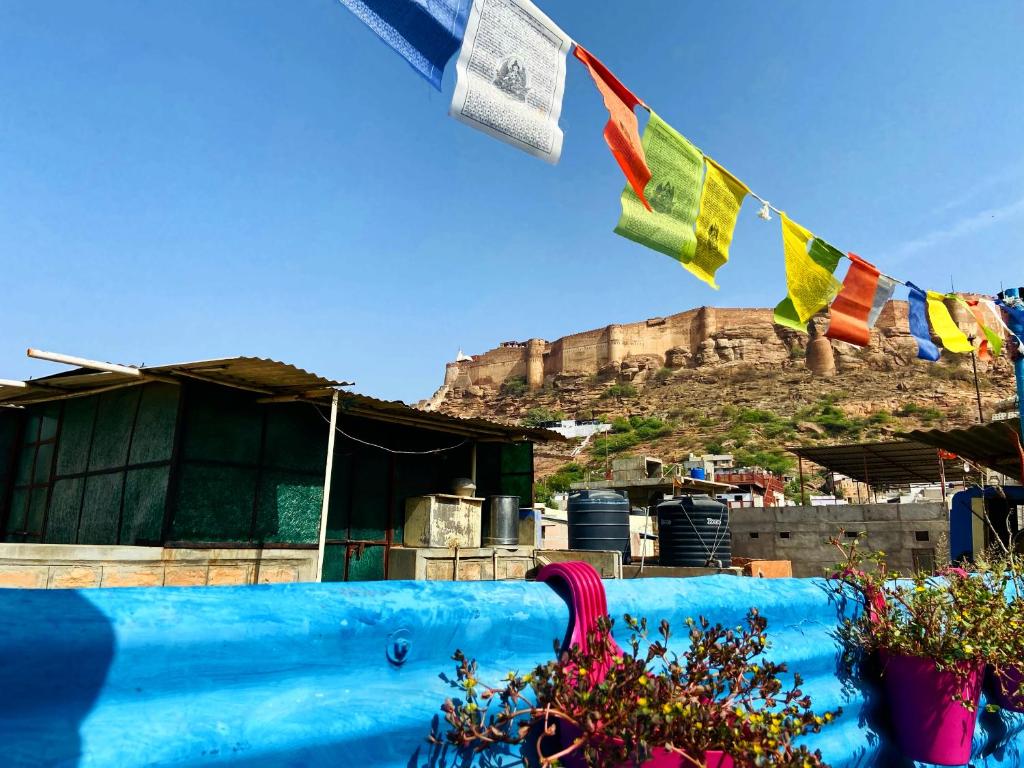 a view of a house with flags on a mountain at Bob hostel Jodhpur in Jodhpur