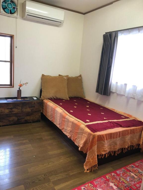 um quarto com uma cama e uma janela em KOTO TEA HOUSE - Vacation STAY 12810 em Kumamoto