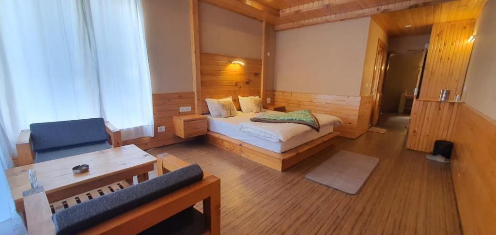 um quarto com uma cama e um sofá num quarto em Hidab Homes em Jibhi