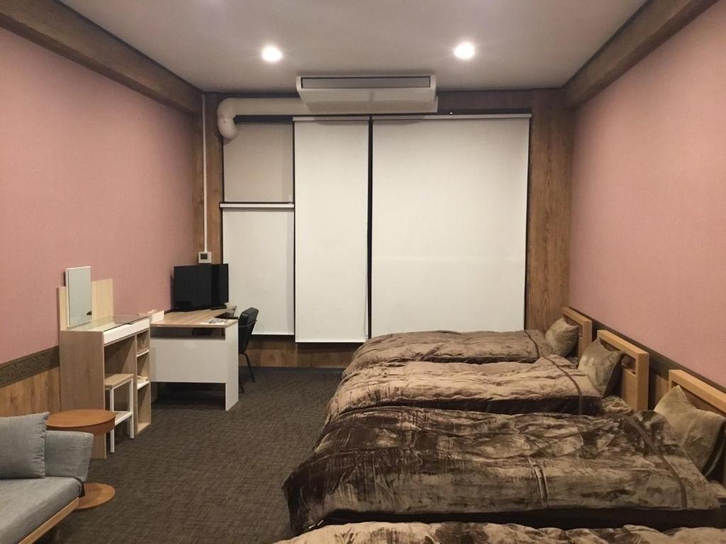 a bedroom with a bed and a desk and a tv at Iitoko - Vacation STAY 43595v in Iitoyo