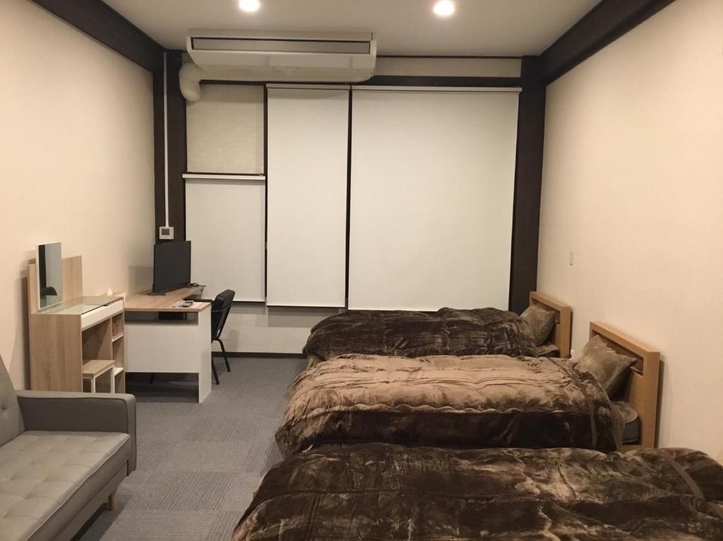 IitoyoにあるIitoko - Vacation STAY 43906vのベッド2台、デスク、コンピュータが備わる客室です。