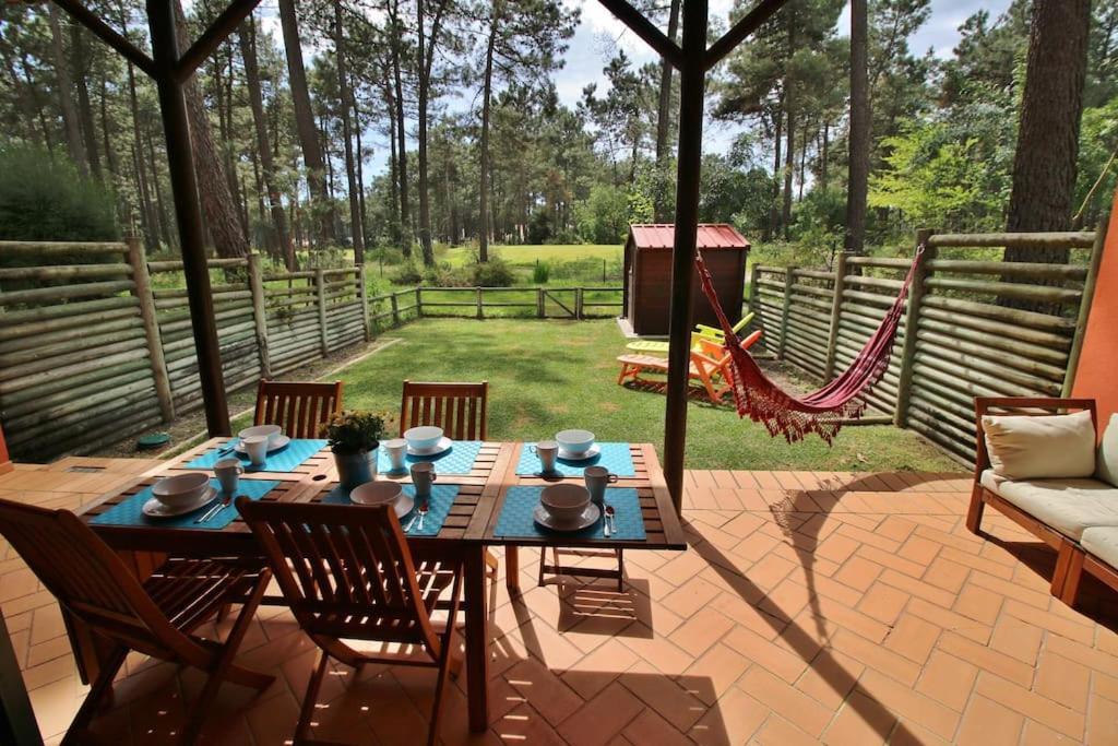 eine Terrasse mit einem Tisch, Stühlen und einer Hängematte in der Unterkunft Apartamento, praia, golfe, Lisboa piscina publica com terifa in Almada