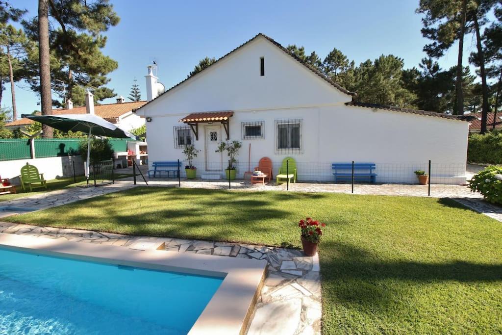 a house with a swimming pool in front of a yard at Casinha; Piscina/ Praia/ Lisboa in Aroeira