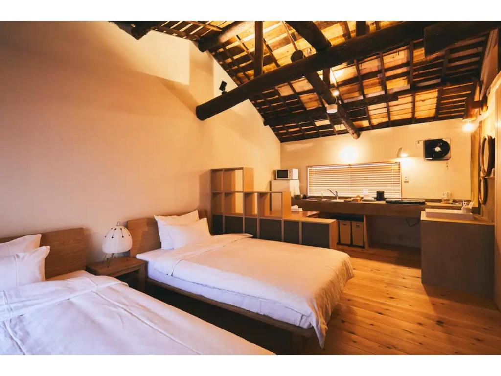 1 Schlafzimmer mit 2 Betten und einem Schreibtisch in einem Zimmer in der Unterkunft Batonship - Vacation STAY 12907 in Osaka
