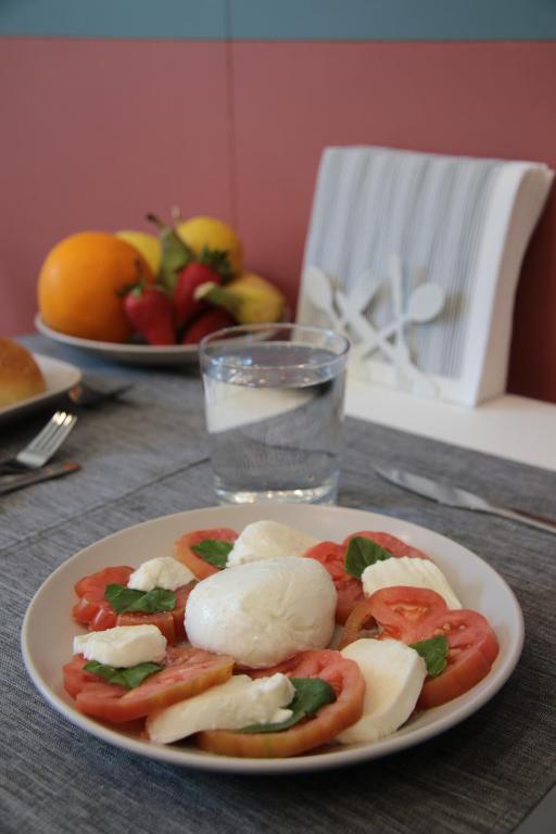 talerz jedzenia z pomidorami i serem na stole w obiekcie Maison Nanà w Sorrento