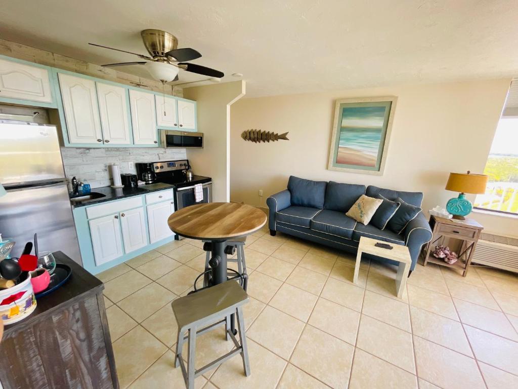 a living room with a blue couch and a kitchen at #808 Gulf View at Lovers Key Beach Club in Fort Myers Beach